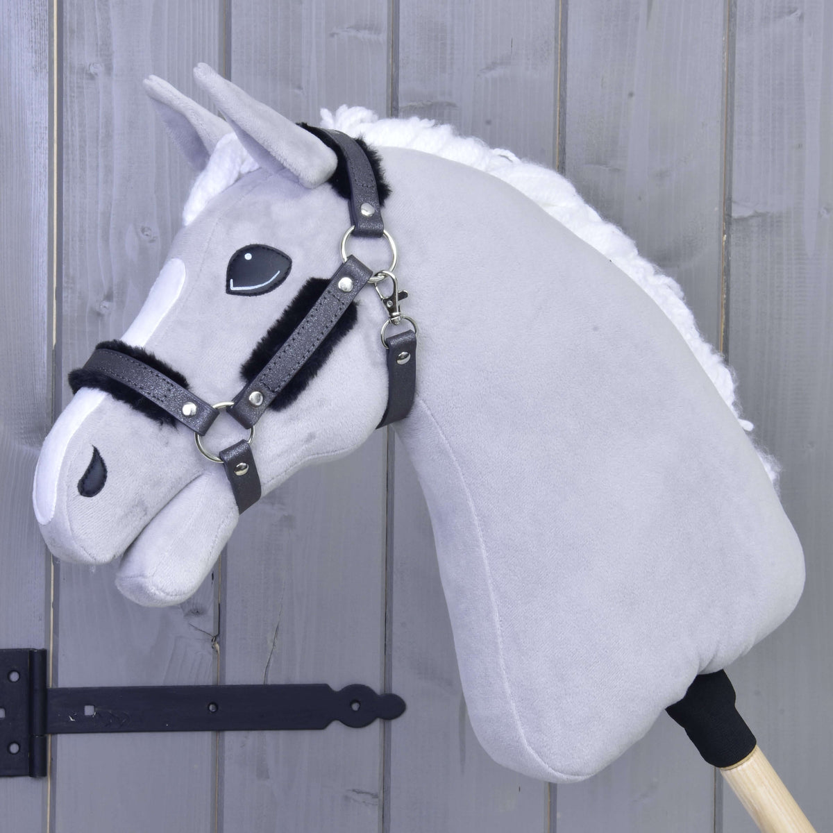Light grey Hobby Horse with white mane wearing the graphite glitter halter with black fur on noseband and cheeks
