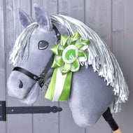 Szürke plüss Hobby Horse ló szürke-fehér fonalsörénnyel és fekete kötőfékkel, a nyakára tűzve a zöld rozetta