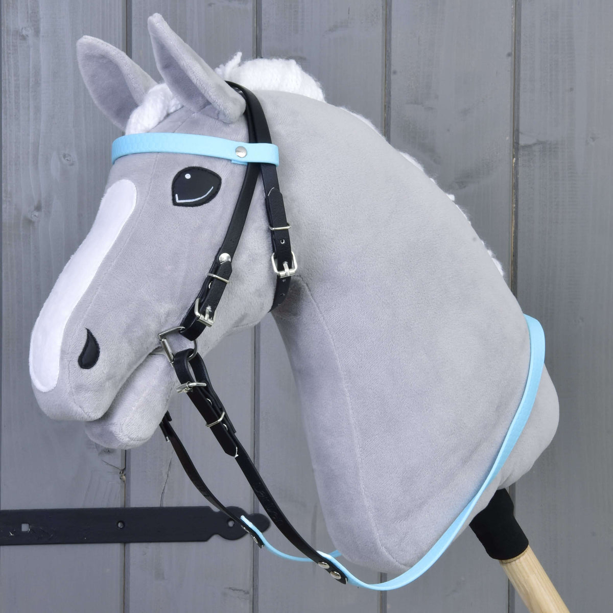 LarDen komplett kantár orrszíj nélkül, Light Blue egy szürke Hobby Horse lovon: fekete szíjak világoskék homlokszíjjal és kantárszárral