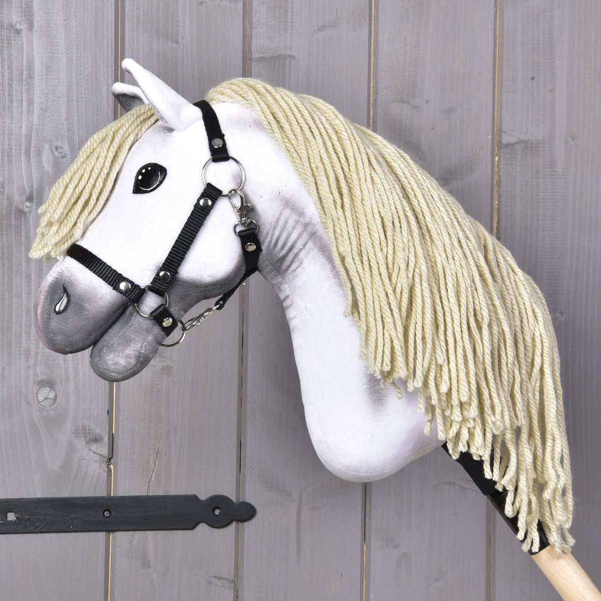 Hobby Horse Little Lady with Black Halter, head lowered, thick cream yarn mane hanging down to the wooden stick