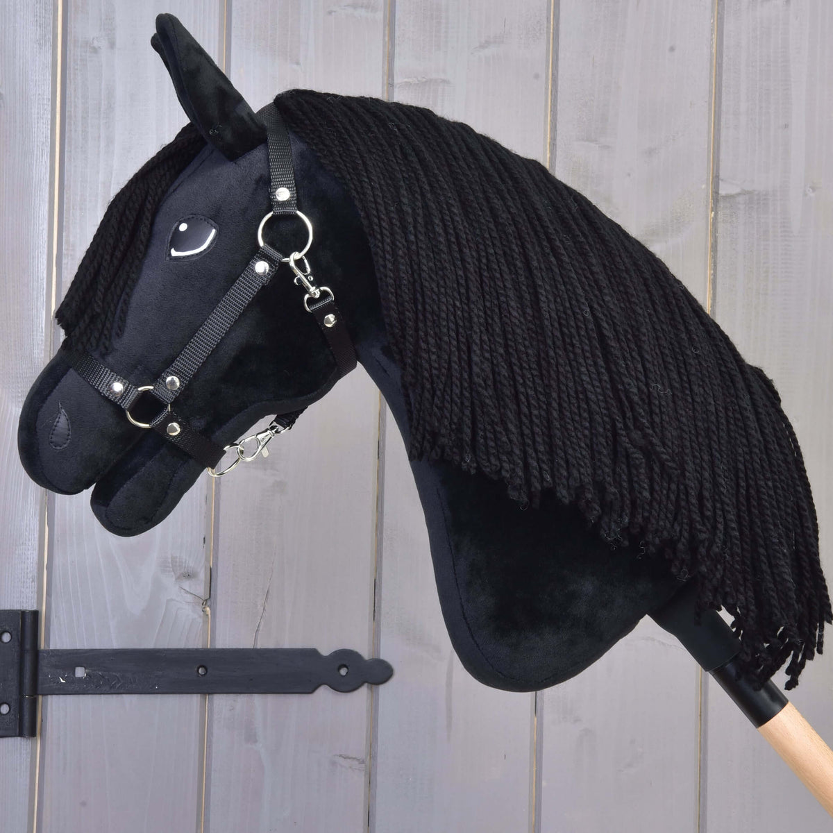 Hobby Horse Mahal fekete kötőfékkel, lehajtott fejjel: dús fekete fonalsörény omlik a fekete plüssnyakra