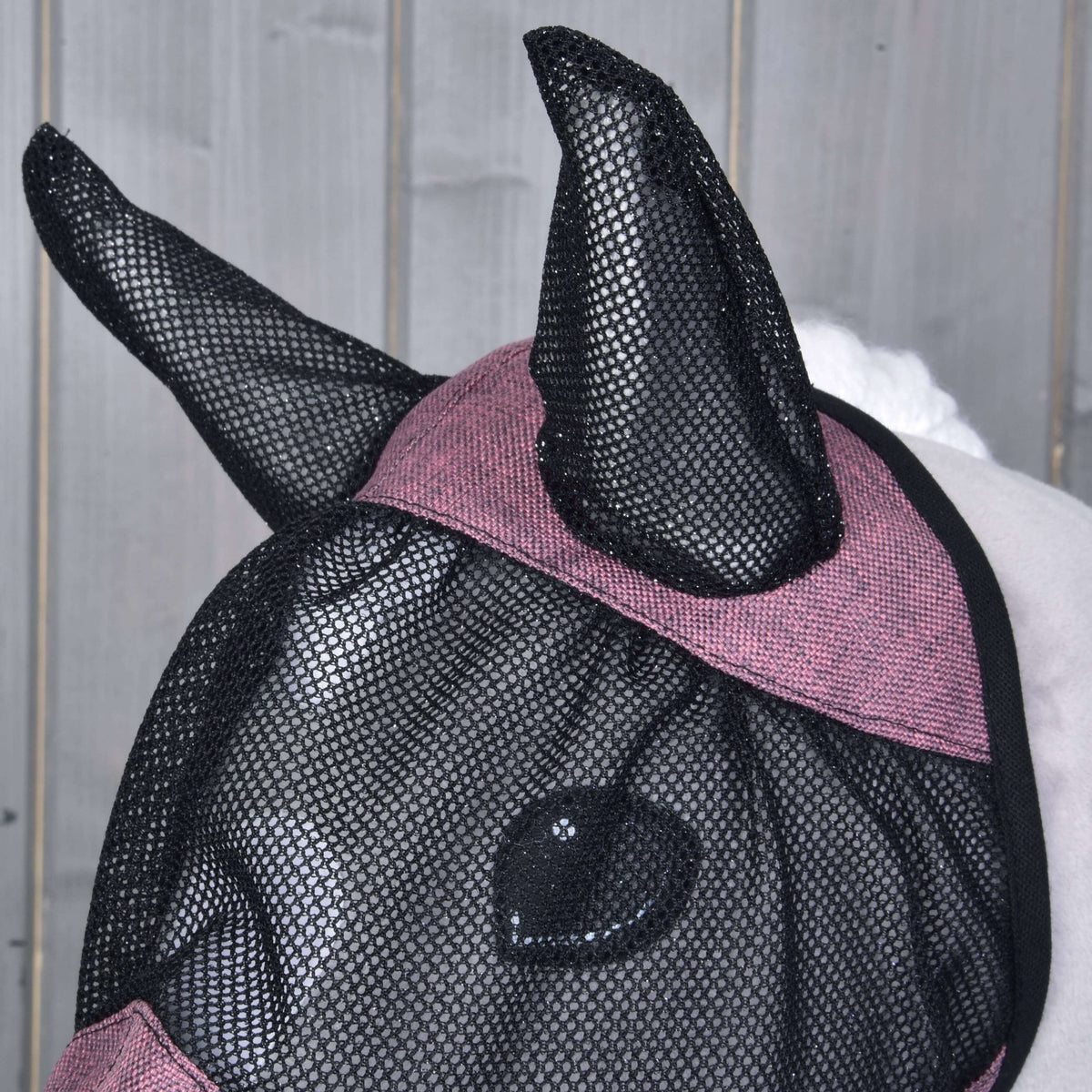Close-up of the black mesh ears and the heathered pink band across the forehead of the fly mask