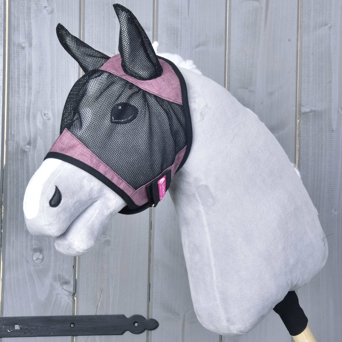 Hobby Horse Fly Mask De Luxe Pink by LarDen on a grey head, black mesh with dusty pink bands and mesh ear covers