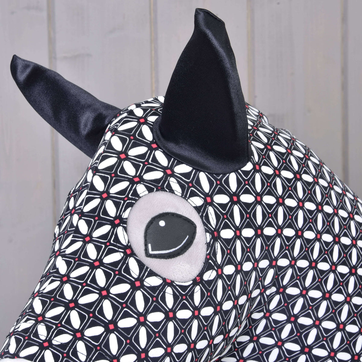 A Hobby Horse DeLuxe védőruha közelről: fekete szaténfül és szemnyílás a geometrikus mintában