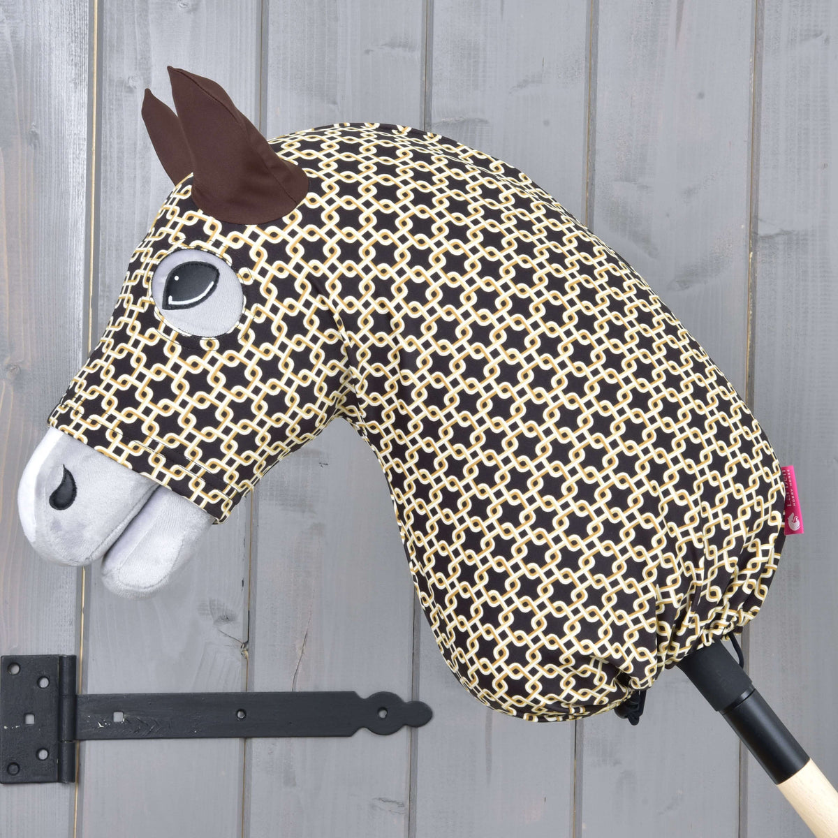 LarDen Hobby Horse Luxus Design védőruha sötétbarna színben, krémszínű láncszemmintával, egy szürke Hobby Horse lovon