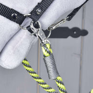 Close-up of a silver snap hook clipping the lemon and grey striped reins to the black halter ring on a grey Hobby Horse