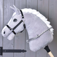 Grey Hobby Horse in a black halter with the grey and white striped rope cordeo around its neck