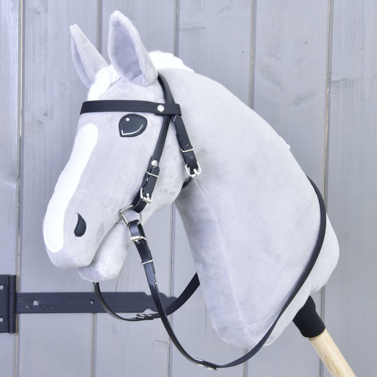 Fehér hókás szürke Hobby Horse ló a fekete kantárban homlokszíjjal, zablával és kantárszárral, de orrszíj nélkül
