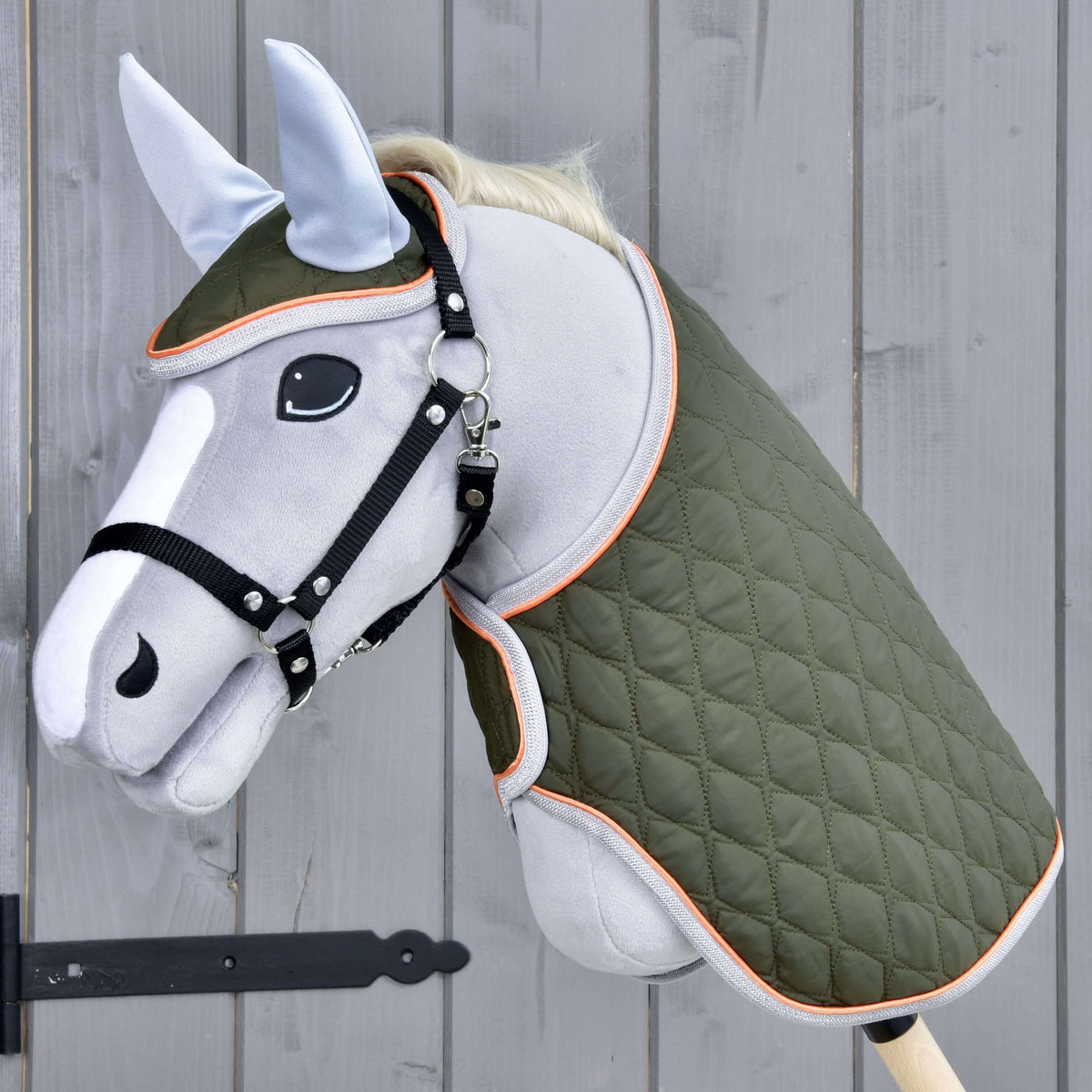 Világosszürke Hobby Horse ló fekete kötőfékben, a Moos szettben: olívazöld steppelt takaró és hozzáillő fülvédő