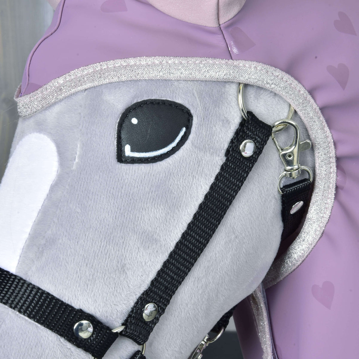 Raincoat Sweetheart up close: silver glitter edging around the face of a grey Hobby Horse in a black halter
