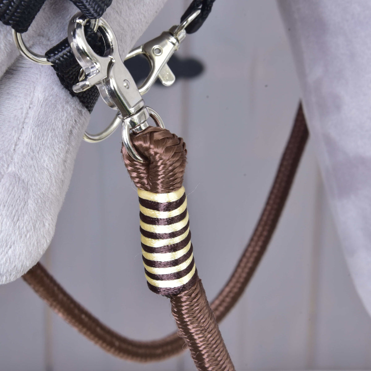 A Hobby Horse Vivaldi kantárszár krémszínű-barna csíkos tekercselése közelről, a karabiner alatt, a kötőfék karikáján