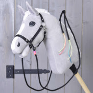 Szürke Hobby Horse ló fekete kötőfékben, fekete western kantárszárral, a nyakán neon zsinórbojtok lógnak