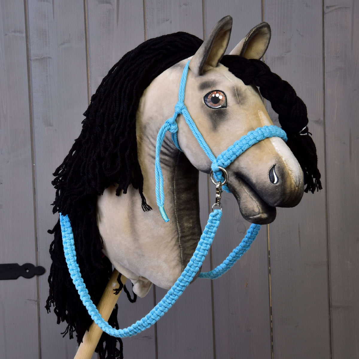Bézs plüss Hobby Horse ló fekete fonalsörénnyel, rajta a világoskék pamut csomózott kötőfék és a fonott kantárszár