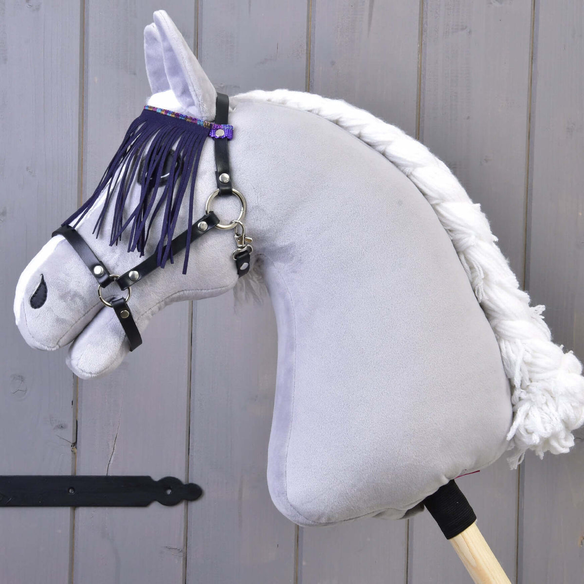 Halter black with lila fringes by LarDen on a grey plush Hobby Horse, the purple fringe hanging over its eye