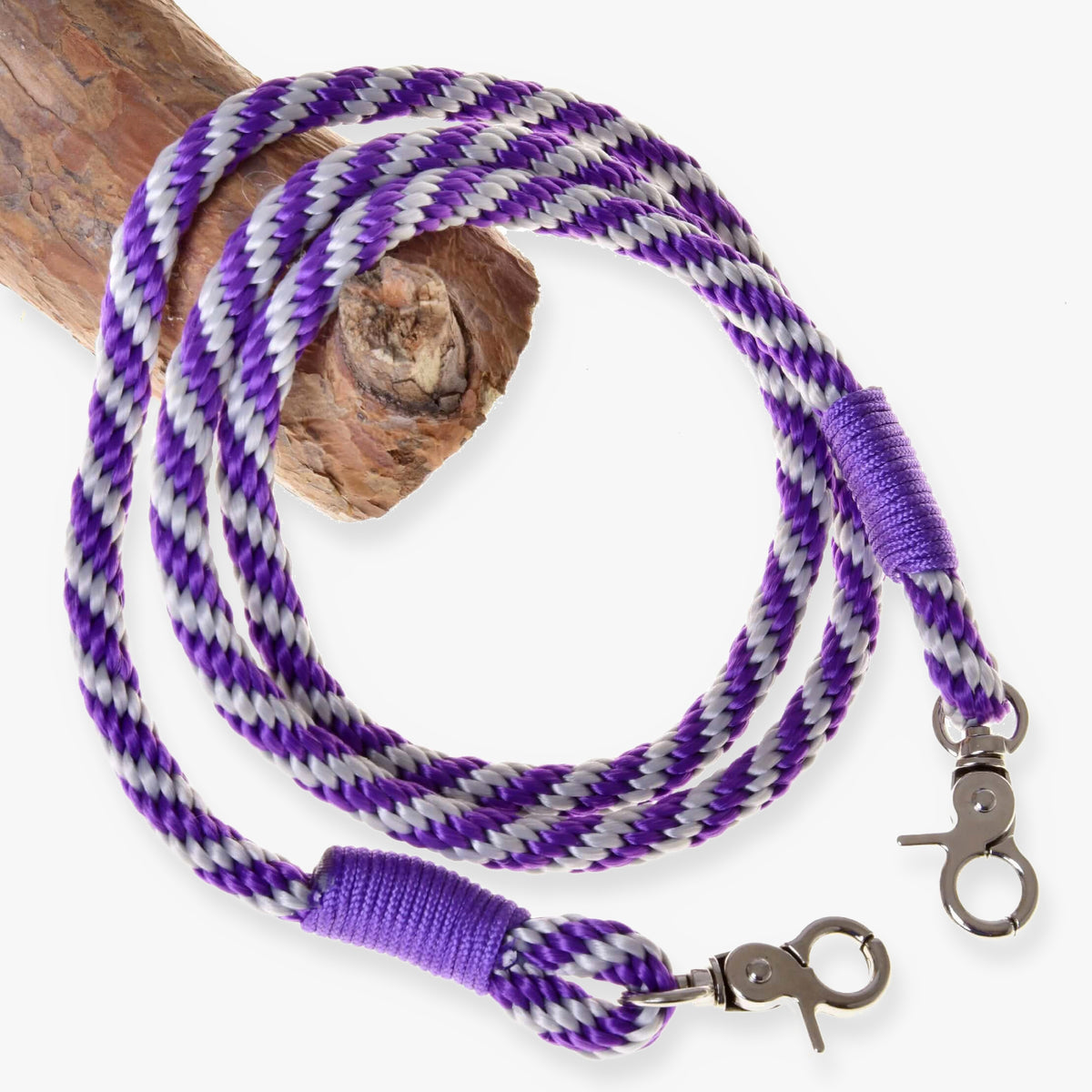 LarDen Hobby Horse Reins Lila Stripe, purple and silver braided rope reins with wrapped ends and snap hooks on a branch